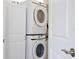 Laundry room with stacked Samsung washer and dryer behind open white door at 455 Orange Ave, St Cloud, FL 34769
