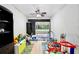 Playroom filled with toys and play equipment, opens to outdoor patio with ceiling fan at 455 Orange Ave, St Cloud, FL 34769