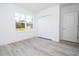 Bedroom featuring a window, closet with bi-fold doors, and a white interior door with light gray wood-look flooring at 506 St Johns Ct, Poinciana, FL 34759