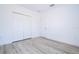 White bedroom features light gray wood-look flooring, a closet with bi-fold doors and a white interior door at 506 St Johns Ct, Poinciana, FL 34759