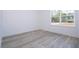 Bright bedroom features light gray wood-look flooring and a large window providing ample natural light at 506 St Johns Ct, Poinciana, FL 34759