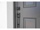 Close-up of a modern front door lock and handle with recessed panels and matching black hardware at 506 St Johns Ct, Poinciana, FL 34759