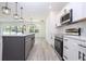Bright kitchen with stainless steel appliances, white cabinets, and stylish lighting fixtures at 506 St Johns Ct, Poinciana, FL 34759
