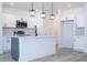 Modern kitchen featuring white cabinets, stainless steel appliances, and a gray kitchen island at 506 St Johns Ct, Poinciana, FL 34759