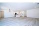 Spacious living room with light gray wood-look floors flows into a modern kitchen with pendant lighting at 506 St Johns Ct, Poinciana, FL 34759