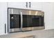 Close up of a stainless steel microwave above a stove with white cabinets at 506 St Johns Ct, Poinciana, FL 34759