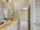 Bright bathroom with double vanity, marble countertops, neutral walls and doorway to bedroom at 5303 Brady Ln, Orlando, FL 32814