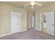 Bedroom with neutral walls, carpeted floor, ceiling fan and multiple doorways for easy access at 5303 Brady Ln, Orlando, FL 32814