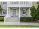 Inviting front porch with gray stairs, trimmed bushes, stylish blue door and shutters, and well manicured lawn at 5303 Brady Ln, Orlando, FL 32814