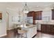 Gourmet kitchen with granite countertops, dark wood cabinets, and stainless-steel appliances next to a dining area at 5303 Brady Ln, Orlando, FL 32814