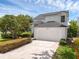 Charming two-story home featuring a manicured lawn, mature trees, and a two-car garage at 554 Queensbridge Dr, Lake Mary, FL 32746