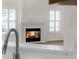 Cozy fireplace with a white brick surround, flanked by shuttered windows at 554 Queensbridge Dr, Lake Mary, FL 32746