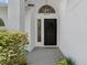 Front door with a wreath and a welcome mat, surrounded by bushes at 554 Queensbridge Dr, Lake Mary, FL 32746