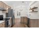 Modern kitchen boasts stainless steel appliances, light wood cabinets, and open layout to the living space at 554 Queensbridge Dr, Lake Mary, FL 32746