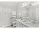 Bright bathroom with double sinks, a large mirror, and a tiled shower with grab bars at 5641 Oak Knoll Dr, St Cloud, FL 34771