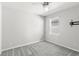 A bright bedroom with soft gray carpet, ceiling fan, and a wall-mounted TV bracket at 5641 Oak Knoll Dr, St Cloud, FL 34771
