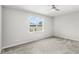 An empty bedroom with gray carpet, ceiling fan, and a window providing natural light at 5641 Oak Knoll Dr, St Cloud, FL 34771