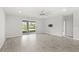 A bright living room offers tile flooring, a ceiling fan, and sliding doors to a screened patio at 5641 Oak Knoll Dr, St Cloud, FL 34771