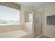 Modern bathroom with a glass-enclosed shower, a soaking tub, and a window with pleasant view at 5908 Paxton Ct, Apopka, FL 32703