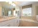 Bright bathroom with double vanity, soaking tub, and large window with decorative valance at 5908 Paxton Ct, Apopka, FL 32703