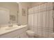 Clean and well-lit bathroom features a shower with curtain and essential fixtures at 5908 Paxton Ct, Apopka, FL 32703