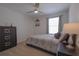 Cozy bedroom with a patterned comforter, dark wood dresser, and ample natural light from the window at 5908 Paxton Ct, Apopka, FL 32703