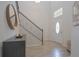 Light and bright entryway with stairway, decorative mirror, dark wood accent table, and light colored wood-look flooring at 5908 Paxton Ct, Apopka, FL 32703