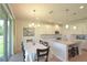 Bright kitchen and dining area featuring white cabinets, granite countertops, stainless steel appliances, and pendant lighting at 5908 Paxton Ct, Apopka, FL 32703