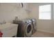 Modern laundry room with stainless steel washer and dryer, utility sink, and built-in shelving at 5908 Paxton Ct, Apopka, FL 32703