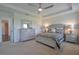 A well-lit main bedroom with a tray ceiling, neutral carpeting, and a decorative dresser with mirror at 5908 Paxton Ct, Apopka, FL 32703