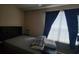 Comfortable bedroom with a large window providing natural light and dark curtains at 6316 Raleigh St # 401, Orlando, FL 32835