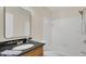 Modern bathroom with black granite countertop, a large mirror, and a shower-tub combo with white tile surround at 648 Kenwick Cir # 102, Casselberry, FL 32707