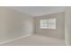 Well-lit bedroom featuring neutral-toned walls and carpet, complemented by a window with horizontal blinds at 648 Kenwick Cir # 102, Casselberry, FL 32707