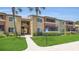 A well-maintained building exterior with lush green landscaping and palm trees on a sunny day at 648 Kenwick Cir # 102, Casselberry, FL 32707