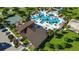 Aerial view of community pool, clubhouse and tennis court with lush landscaping and ample seating at 700 Trotters Dr, Eagle Lake, FL 33839