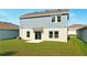 Lush backyard features a neatly kept lawn, enhanced by a sliding glass door, creating a perfect blend of indoor and outdoor living at 700 Trotters Dr, Eagle Lake, FL 33839