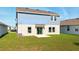 Expansive backyard featuring lush green grass and a sliding glass door providing access to indoor living space at 700 Trotters Dr, Eagle Lake, FL 33839