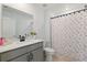 Well-lit bathroom features a modern sink and vanity, floral shower curtain, and white walls at 700 Trotters Dr, Eagle Lake, FL 33839