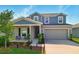 Charming two-story home with a covered front porch and a well-manicured lawn at 700 Trotters Dr, Eagle Lake, FL 33839