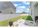 Wide backyard with putting green, grass, and a stone patio with a flower pot in the corner at 701 Dennis Ave, Orlando, FL 32807