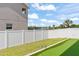 Spacious backyard featuring a putting green and a well-maintained white privacy fence at 701 Dennis Ave, Orlando, FL 32807
