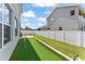 Wide backyard view showing putting green, green grass, and neighboring home at 701 Dennis Ave, Orlando, FL 32807