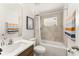 Bright bathroom featuring a tub-shower combo, modern vanity, and neutral tile at 701 Dennis Ave, Orlando, FL 32807