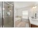 Bright bathroom featuring a glass enclosed shower, soaking tub, and double vanity at 701 Dennis Ave, Orlando, FL 32807