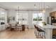Bright dining area featuring a modern table set and large windows, next to the island with pendant lights at 701 Dennis Ave, Orlando, FL 32807