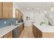Spacious kitchen with wood cabinets, stainless steel appliances, a white countertop island, and pendant lighting at 701 Dennis Ave, Orlando, FL 32807