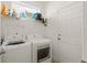 Functional laundry room with a washer, dryer, and storage shelf, offering convenience at 701 Dennis Ave, Orlando, FL 32807