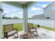 View from the covered patio of backyard has lush lawn, putting green, and privacy fence at 701 Dennis Ave, Orlando, FL 32807