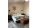 Comfortable bedroom features a queen-sized bed with a padded bench and gray wood-look flooring at 707 Carpenters Way # 50, Lakeland, FL 33809
