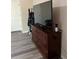 Bedroom with gray vinyl floors, doors, and a large dresser with a TV for entertainment at 707 Carpenters Way # 50, Lakeland, FL 33809